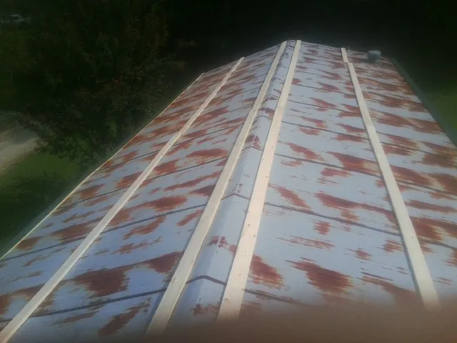 Rusted metal roof panels with new wood purlins before replacement — Storm Damage Roof Repair in Fall River by Roofing Brothers