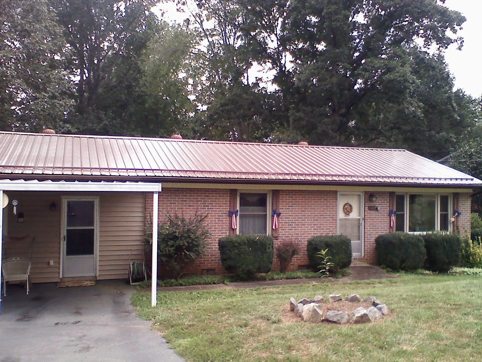 Bronze metal roof and carport on a brick ranch home — Roof Repair work by our crew in Fall River